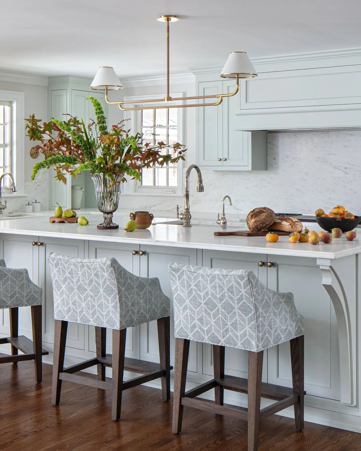 A custom kitchen by Virginia Cabinetry with a marble topped island and painted cabinetry