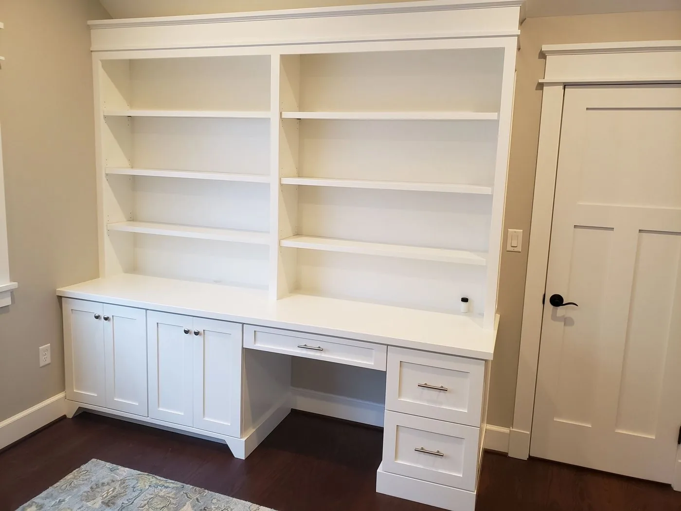 White built-in bookcases flanking a built-in desk