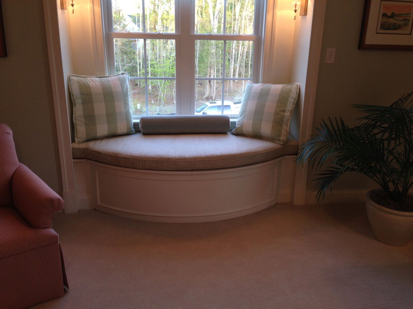 A curved built-in window seat under a bay window