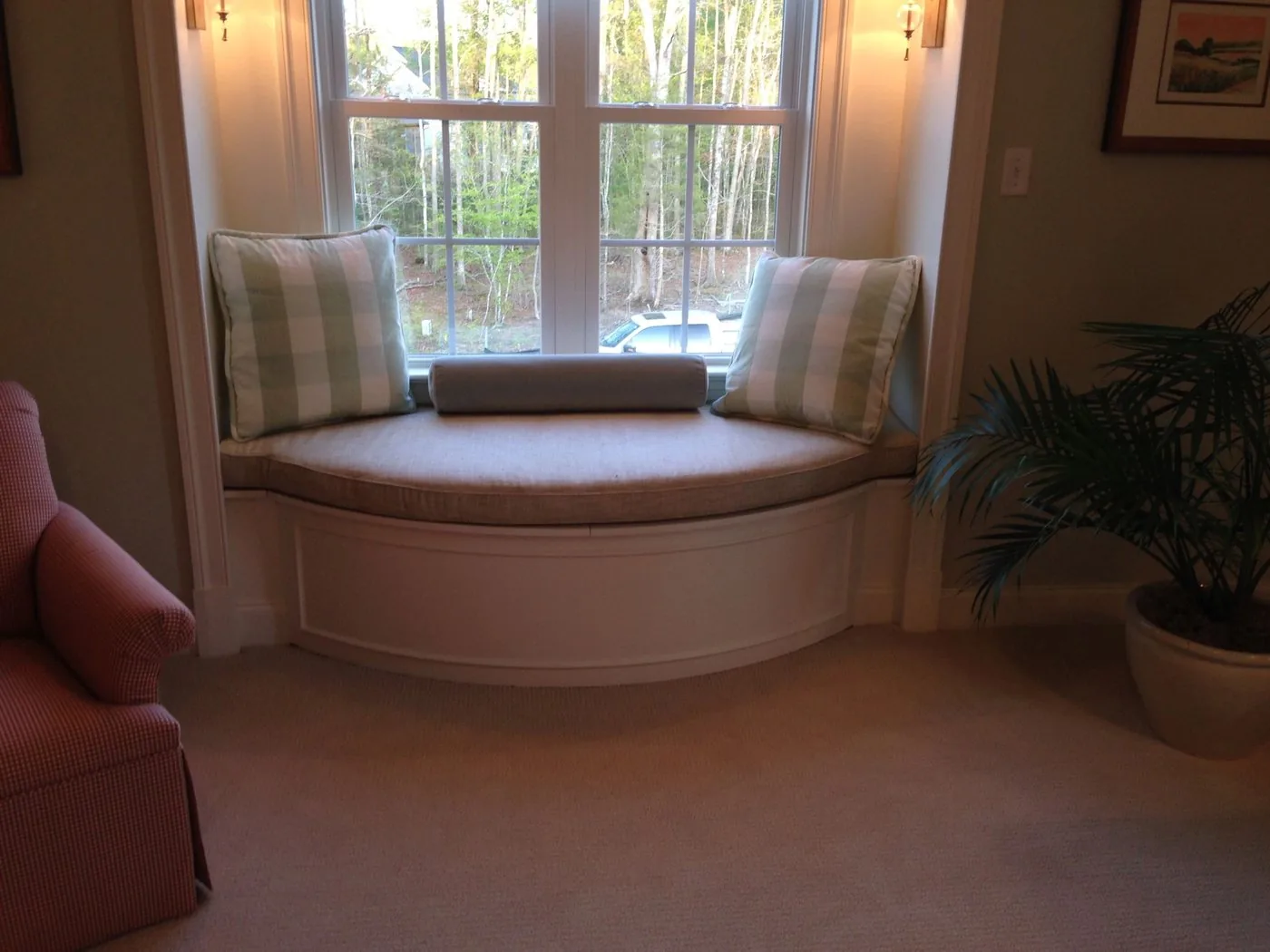 A curved built-in window seat under a bay window
