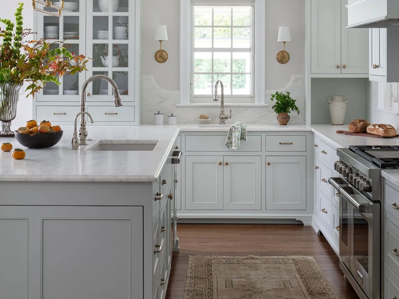 A painted wood hood over a range in a white kitchen