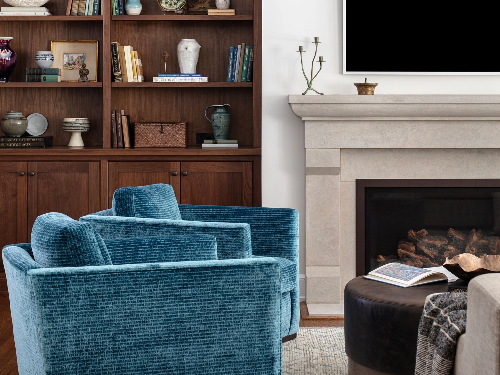 A living room with built-in walnut shelving beside a fireplace