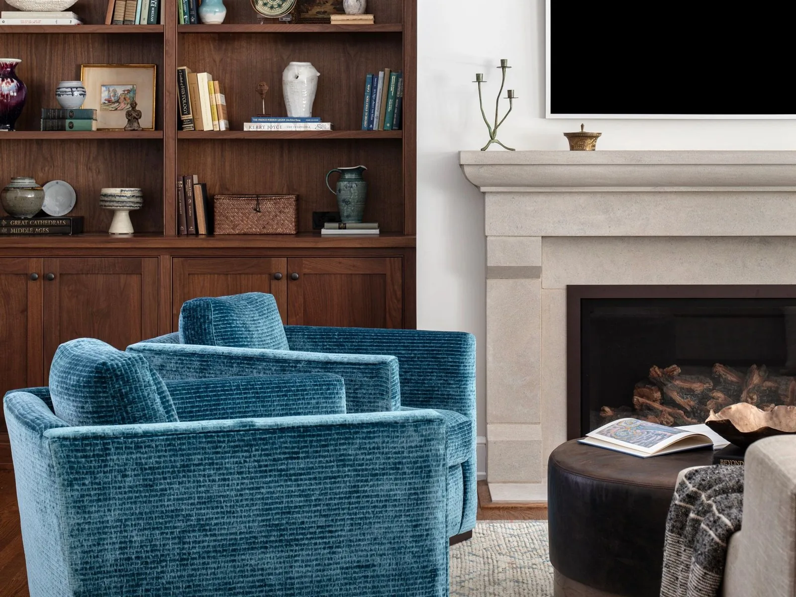 A living room with built-in walnut shelving beside a fireplace